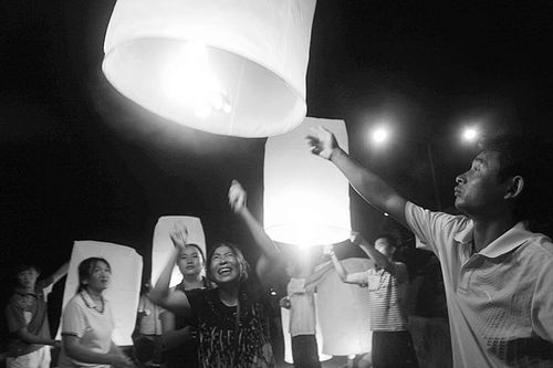 13日晚,在泰国清盛举行的追思会现场点亮孔明灯,悼念逝去的中国船员