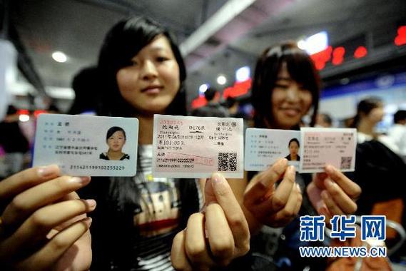 6月1日,两名旅客在沈阳北站展示自己的身份证和动车车票.